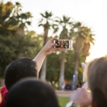 A group of students taking a selfie in front of fountain at Old Main.